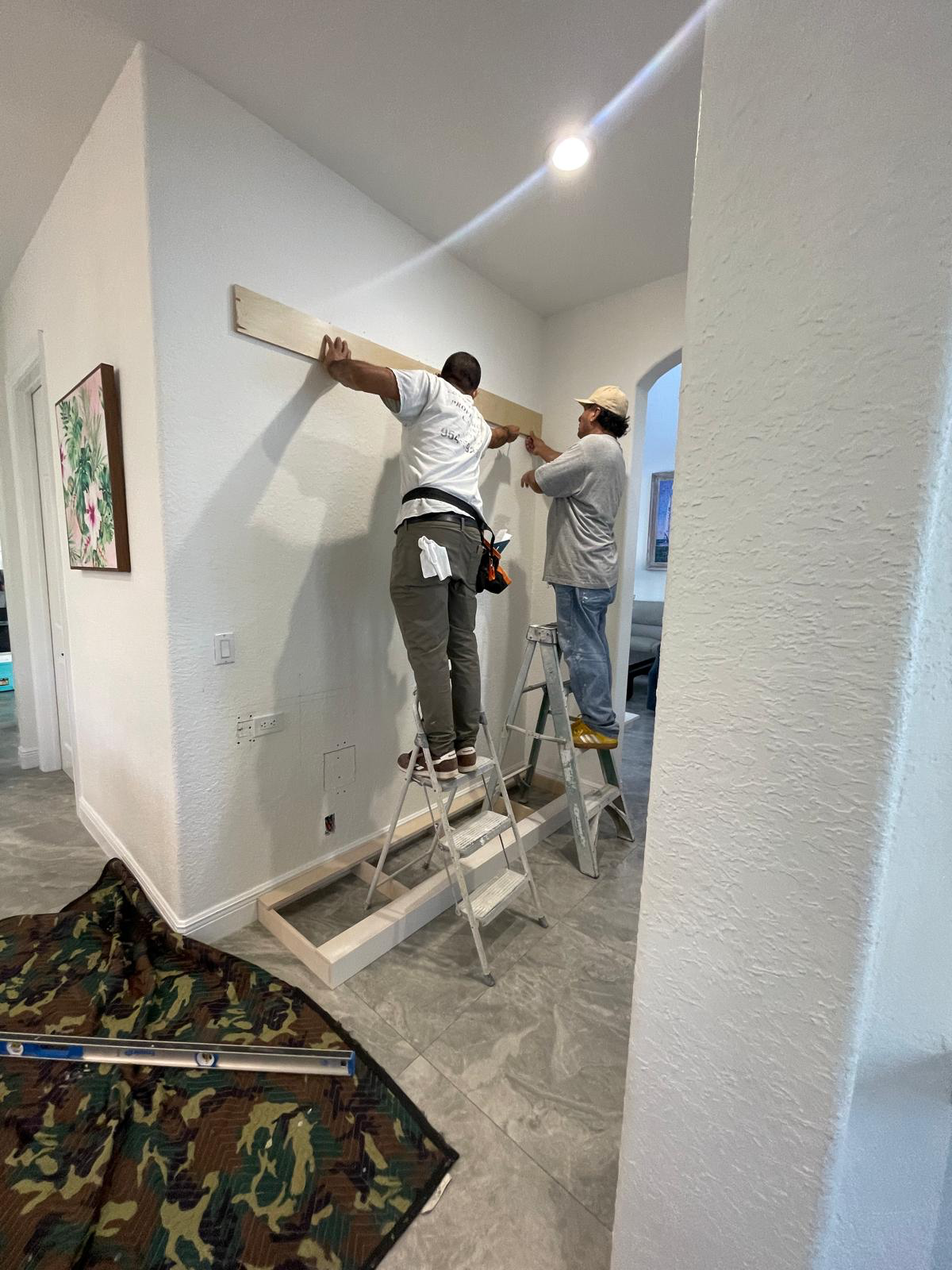 Two CQ Woodworking team members setting a wall-unit frame in place during assembly