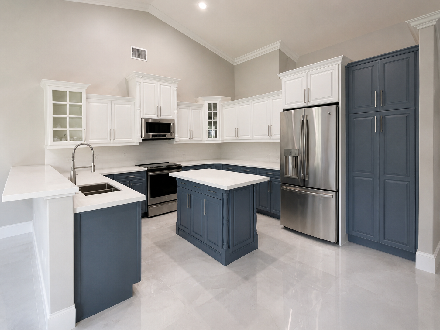 Two-tone kitchen with white upper cabinets, slate blue base cabinets and island, and white countertops
